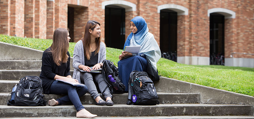 a group of students sitting outdoors chatting